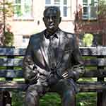 Life-sized bronze coloured statue of a man wearing a suit